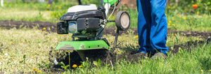gardener tilling grass into a garden bed