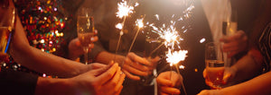 friends celebrate New Year's Eve with sparklers and drinks