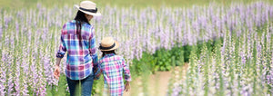 mother and daughter walking through digitalis flower patch