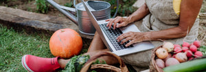 woman on laptop with vegetables around her
