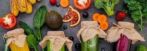 fruits and vegetables with juice on a grey background
